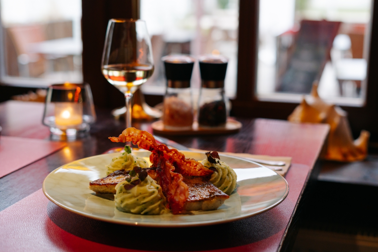 Ein Fischgericht im Blinkfür mit einem Glas Wein