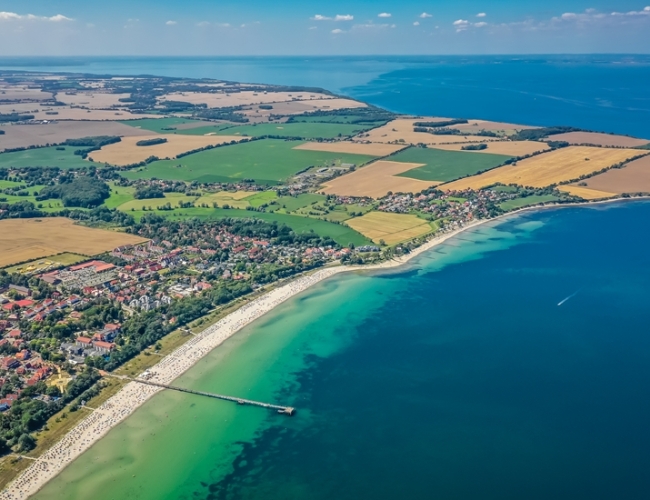 Der feinsandige Strand, die Steilküste, die 290 Meter in die Ostsee ragenden Seebrücke und der Küstenwald, betten den Ort in ein grünes Band.