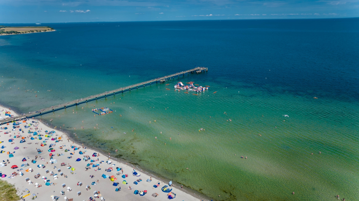 Der volle Strand an der Ostsee in Boltenhagen zur Hochsaison bei wunderschönem, strahlend blauen Himmel. 