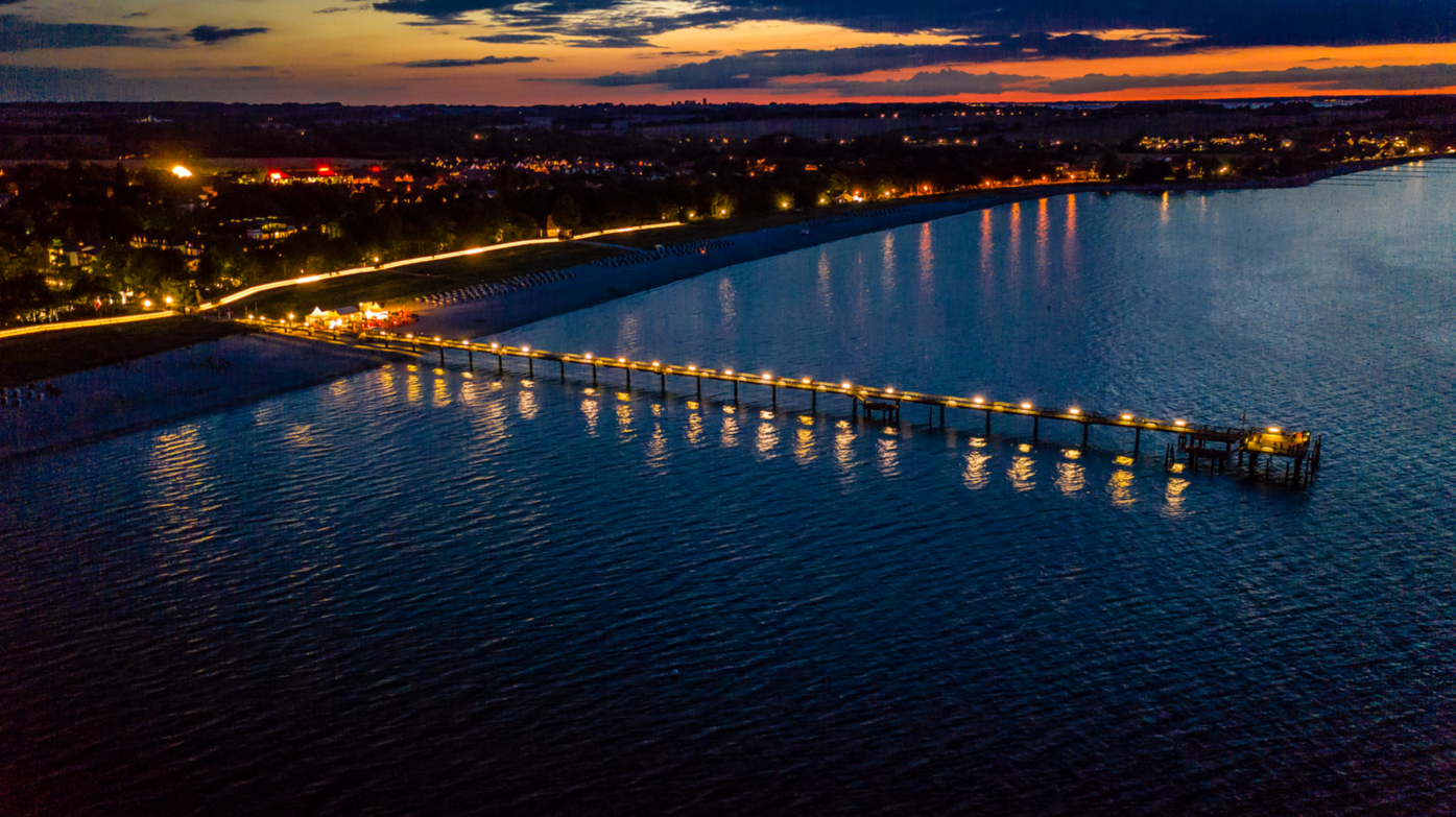 Luftaufnahme von der Seebrücke am Abend mit Lichtern
